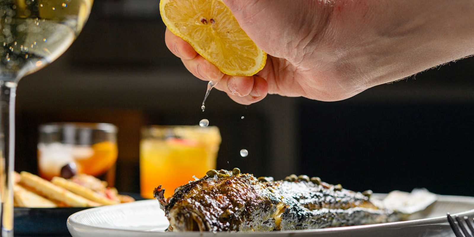Whole Bronzino grilled over an open flame.