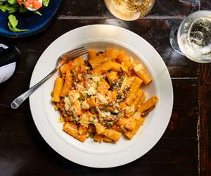 Rigatoni in a carrot-based cream sauce with mushrooms, peas and pecorino romano.